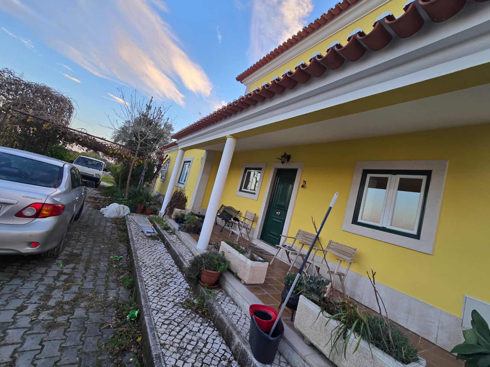 Moradia com fachada pintada de amarelo e alpendre