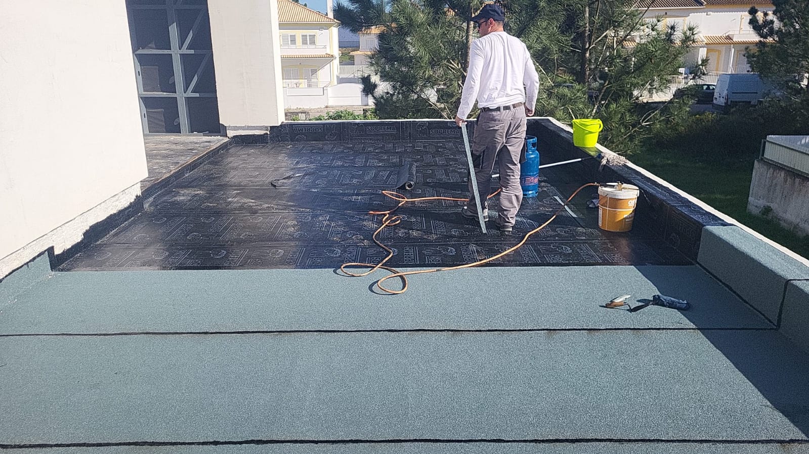 Técnico a aplicar impermeabilização num terraço