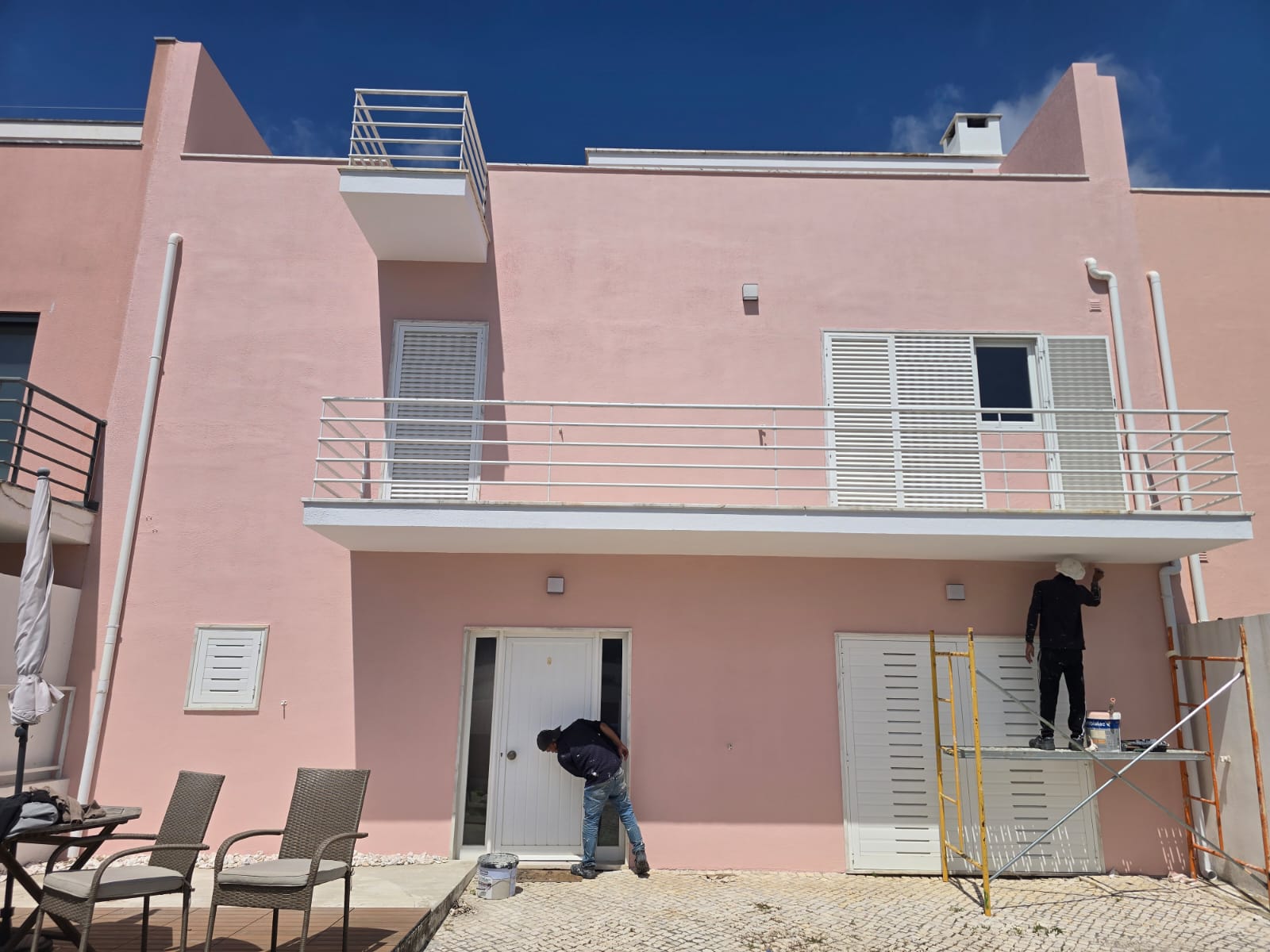 Equipa da Constelação Forasteira a pintar a fachada de uma moradia