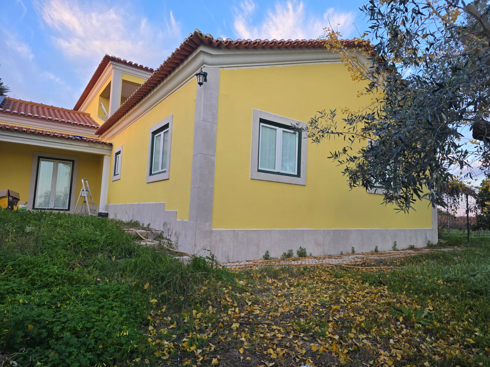 Fachada de moradia pintada de amarelo, vista de canto